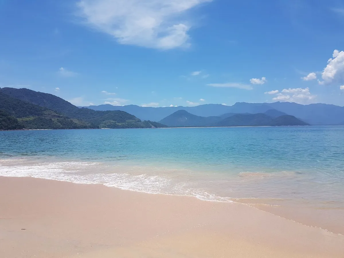 Praia da Ilha do Prumirim em dia de mar calmo com água limpa e transparente