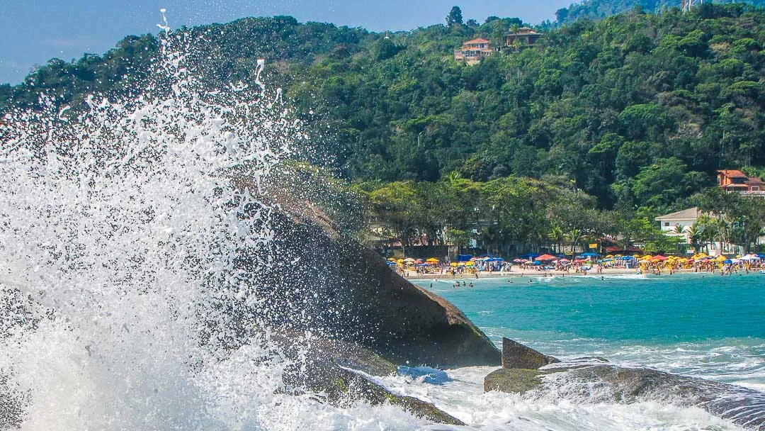 Praia do Tenório em Ubatuba com faixa de areia, guarda-sóis, banhistas e mar em dia ensolarado